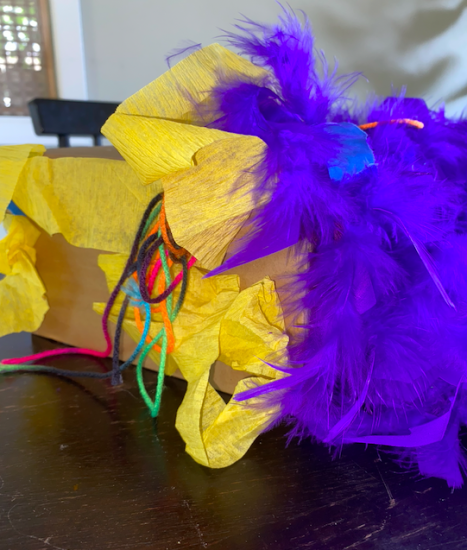 yellow streamers and purple feather boa on side of box.